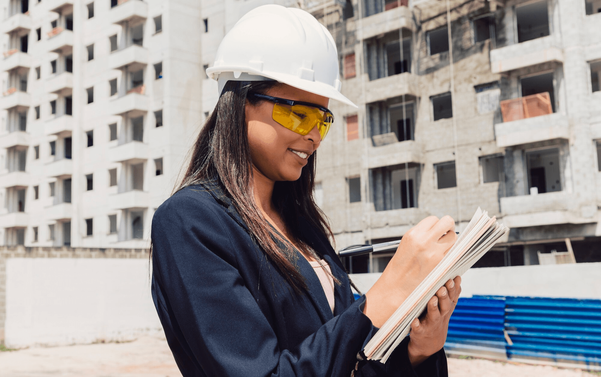 Golden Rewards engineer in PPE reviewing site notes on a live project