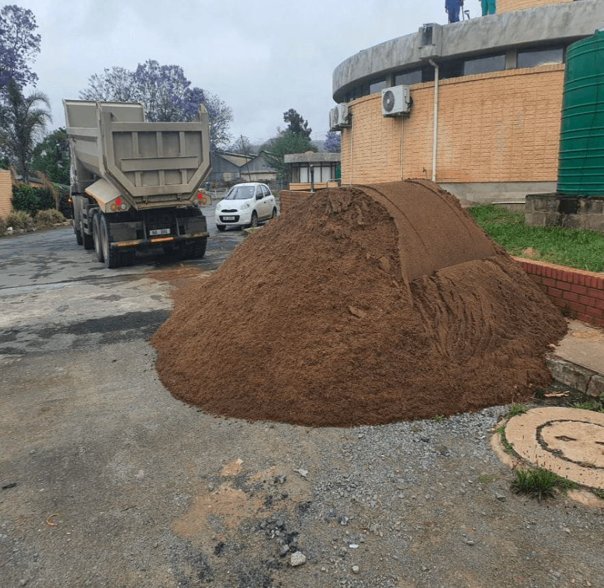 Excavated spoil heap and tipper truck at a municipal earthworks site